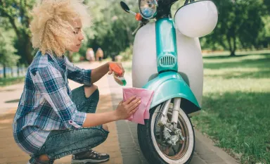 Femme qui nettoie un scooter