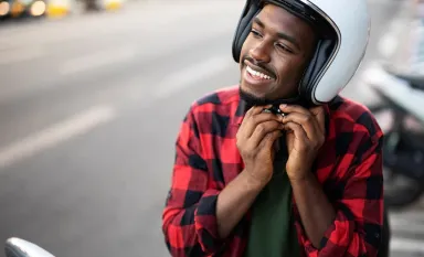 Jeune homme enfilant un casque de moto