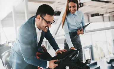 Une vendeuse discutant avec un client pour l'achat d'une moto