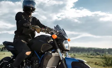Un motard conduisant sa moto sur une route ensoleillée