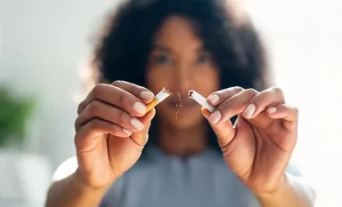 Une jeune femme cassant une cigarette en deux