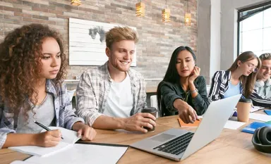 Un groupe d'étudiants travaillant ensemble devant un pc portable