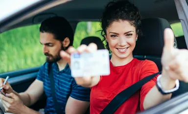 Une jeune fille avec un t-shirt rouge qui vient d'obtenir son permis de conduire