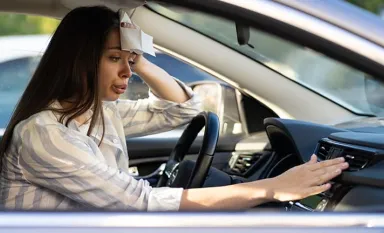 Une jeune souffrant de la chaleur dans sa voiture