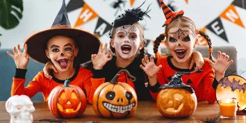 Des enfants déguisés faisant des grimaces dans un décor Halloween