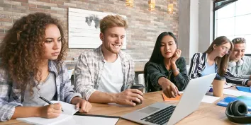 Un groupe d'étudiants travaillant ensemble devant un pc portable