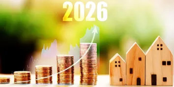 Des piles de pièces et des petites maisons en bois surmontées de l'année 2026