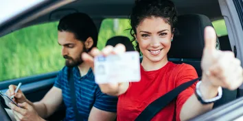 Une jeune fille avec un t-shirt rouge qui vient d'obtenir son permis de conduire