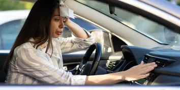 Une jeune souffrant de la chaleur dans sa voiture