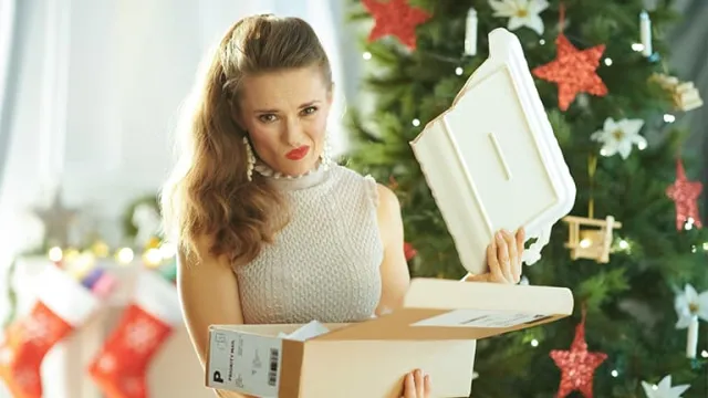 Une jeune femme déballant son cadeau et découvrant un plat cassé