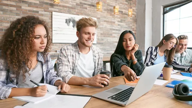 Un groupe d'étudiants travaillant ensemble devant un pc portable