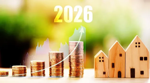 Des piles de pièces et des petites maisons en bois surmontées de l'année 2026
