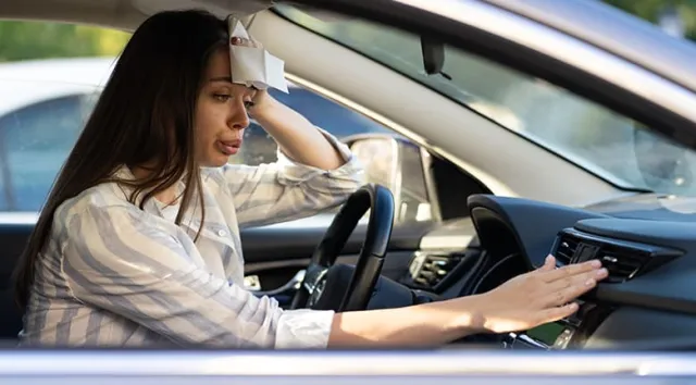 Une jeune souffrant de la chaleur dans sa voiture