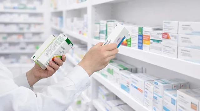 Un pharmacien préparant des boites de médicaments