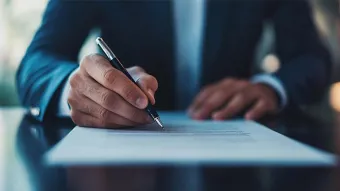 Un homme en costume sombre en train de signer un contrat